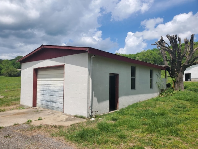 188 Bradford Hill Rd N, Brush Creek, TN 38547 - view of side of home with concrete driveway, an outbuilding, concrete block siding, and a garage