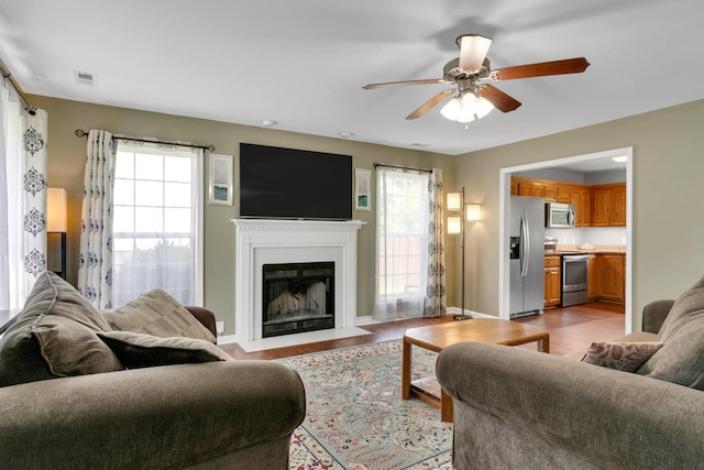 1244 Baker Creek Dr, Spring Hill, TN 37174 - living area with visible vents, a fireplace with flush hearth, plenty of natural light, and ceiling fan