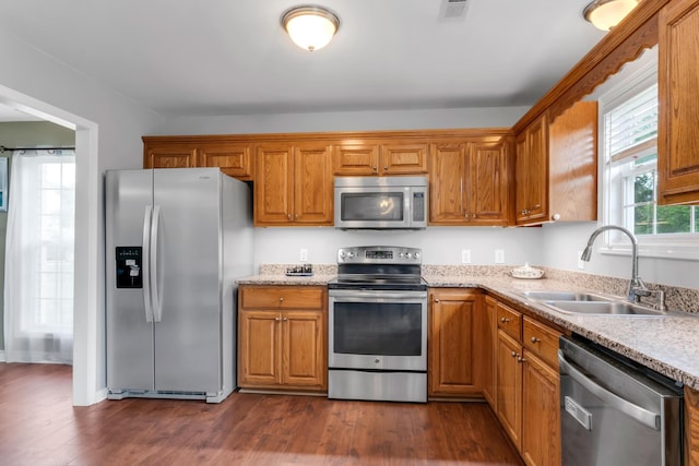 1244 Baker Creek Dr, Spring Hill, TN 37174 - kitchen with appliances with stainless steel finishes, a sink, dark wood finished floors, brown cabinetry, and visible vents
