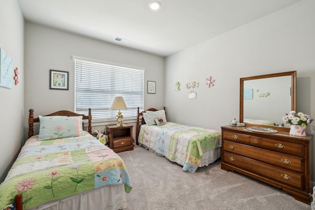 carpeted bedroom featuring visible vents