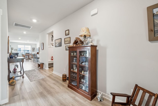hall with visible vents, recessed lighting, light wood finished floors, and baseboards