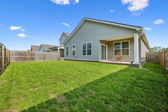 back of property featuring a fenced backyard, a lawn, and a patio area