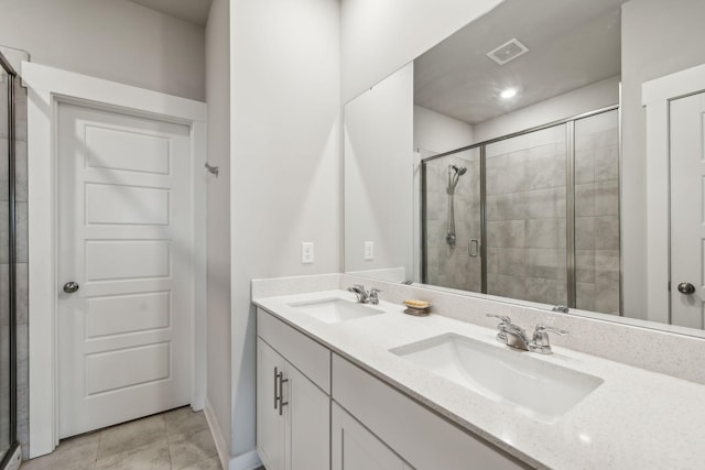 bathroom featuring a sink, a stall shower, double vanity, and visible vents