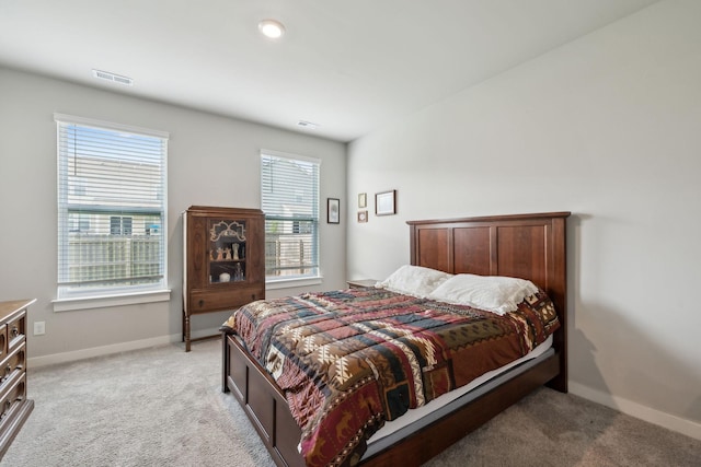 bedroom with visible vents, baseboards, and light colored carpet