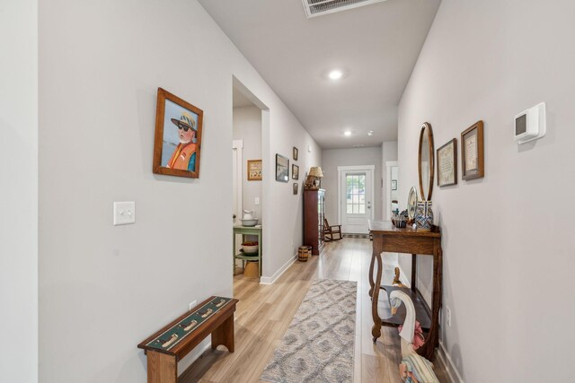 hall with light wood-type flooring, recessed lighting, baseboards, and visible vents