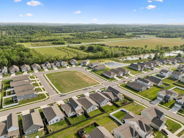 drone / aerial view featuring a residential view, a water view, and a forest view
