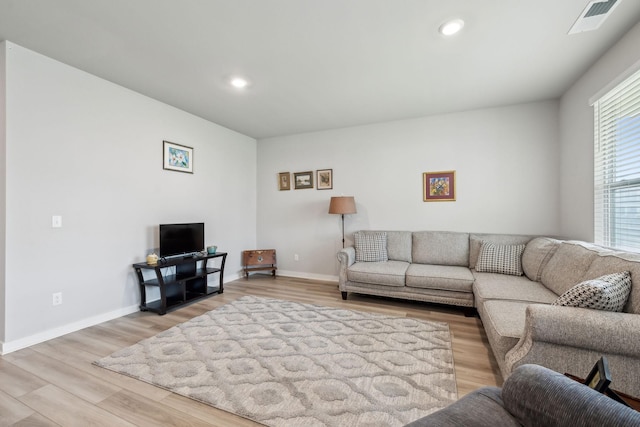 living room featuring baseboards, recessed lighting, light wood-style flooring, and visible vents