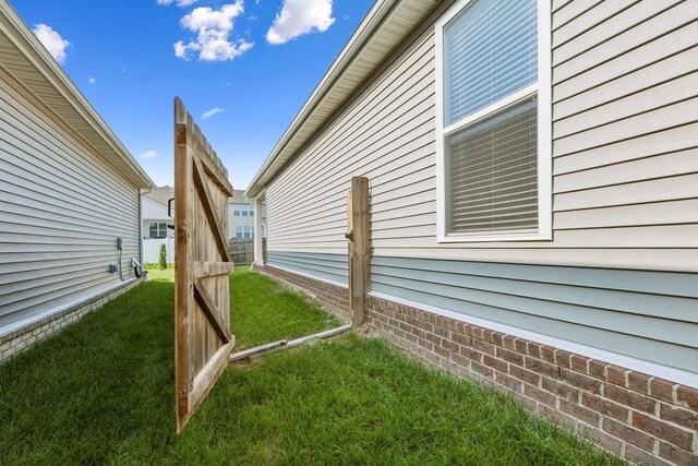 view of side of home with a yard