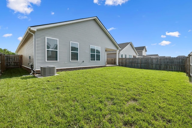 back of house featuring a lawn, a fenced backyard, and cooling unit