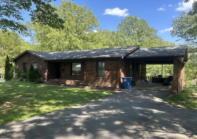 ranch-style home featuring brick siding, an attached carport, driveway, and a front yard
