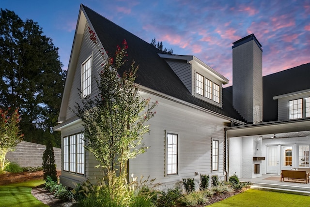 1105 Brookmeade Dr, Nashville, TN 37204 - back of house at dusk with a patio, a lawn, and a chimney