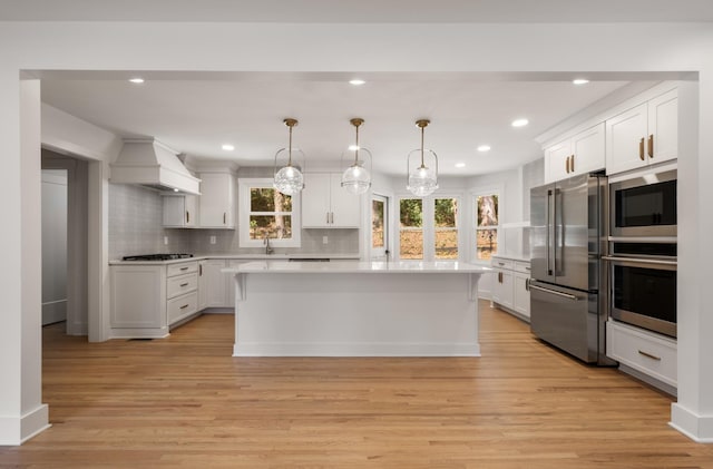 6556 Jocelyn Hollow Rd, Nashville, TN 37205 - kitchen featuring light countertops, stainless steel appliances, custom exhaust hood, and light wood-type flooring