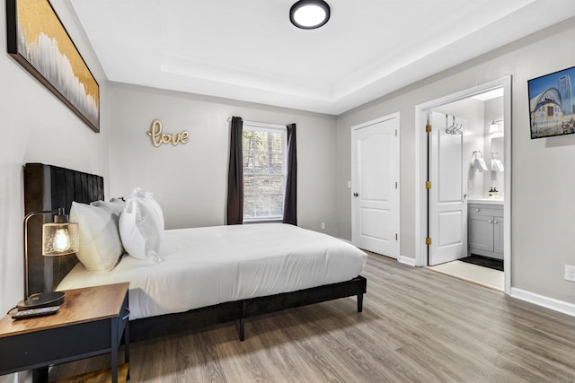 2821 Old Matthews Rd, Nashville, TN 37207 - bedroom featuring connected bathroom, baseboards, wood finished floors, and a raised ceiling