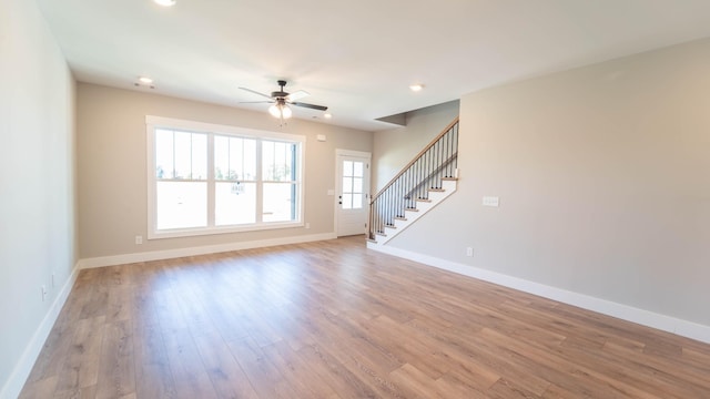 unfurnished living room with ceiling fan, light wood-style floors, stairs, recessed lighting, and baseboards