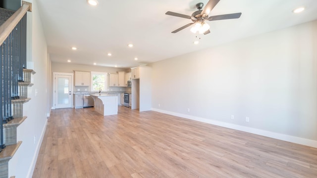 unfurnished living room featuring light wood-type flooring, recessed lighting, baseboards, and ceiling fan