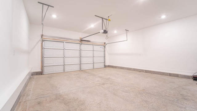 garage with recessed lighting, baseboards, and a garage door opener