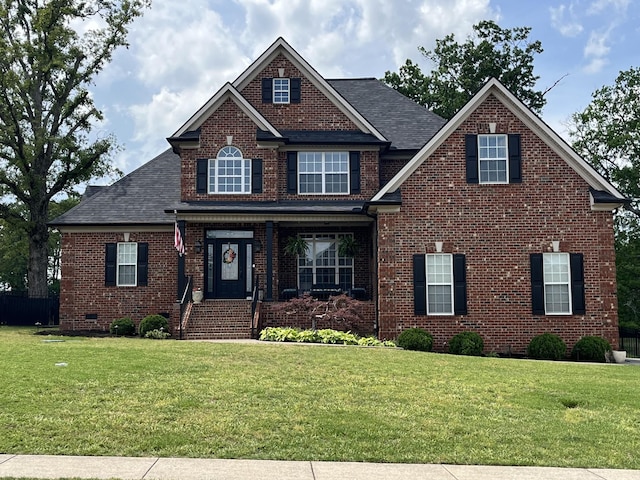 craftsman house featuring a shingled roof, a front lawn, and brick siding