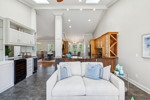 1403 Sneed Rd W, Franklin, TN 37069 - living room with baseboards, ornamental molding, vaulted ceiling, and beverage cooler