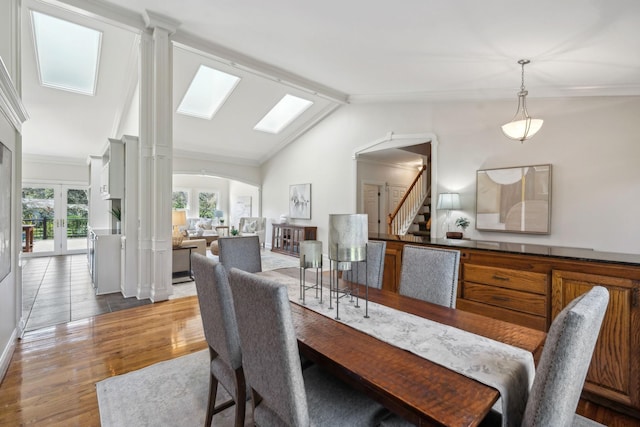 1403 Sneed Rd W, Franklin, TN 37069 - dining space with crown molding, arched walkways, wood finished floors, stairway, and lofted ceiling with skylight