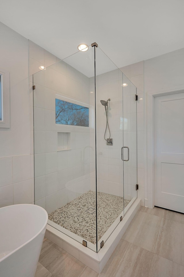 full bath featuring a stall shower, a soaking tub, and recessed lighting