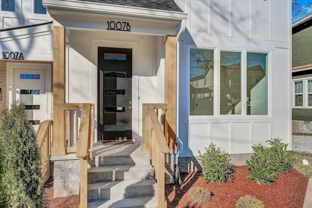 doorway to property with roof with shingles