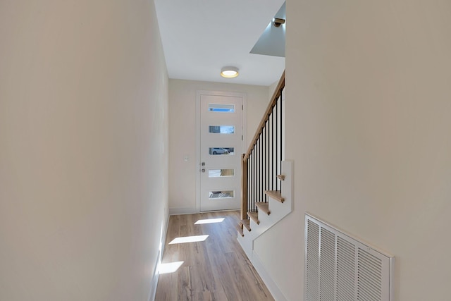 corridor featuring stairway, wood finished floors, and baseboards