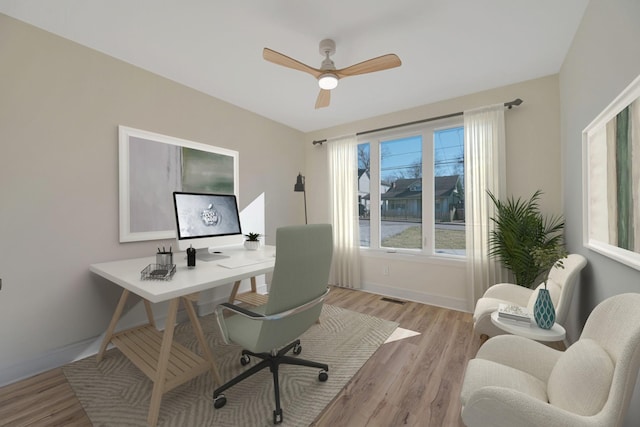 office space featuring light wood finished floors, a ceiling fan, and baseboards