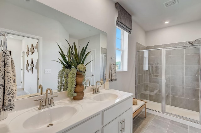 bathroom with visible vents, a sink, double vanity, and a shower stall