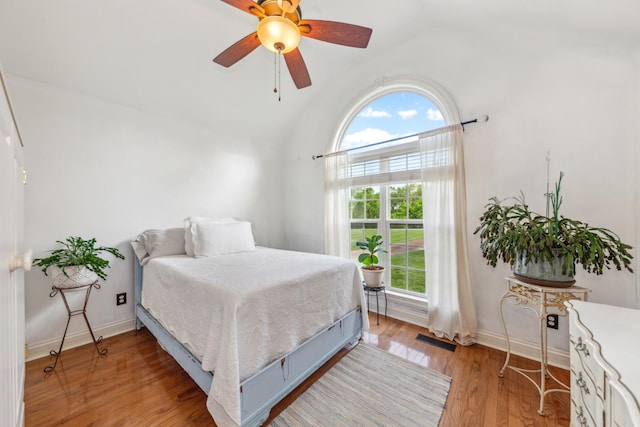bedroom featuring vaulted ceiling, multiple windows, visible vents, and light wood-type flooring