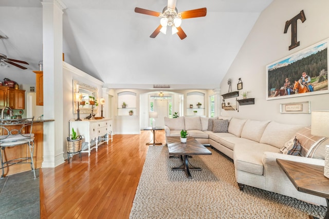 living room with high vaulted ceiling, a ceiling fan, arched walkways, and wood finished floors