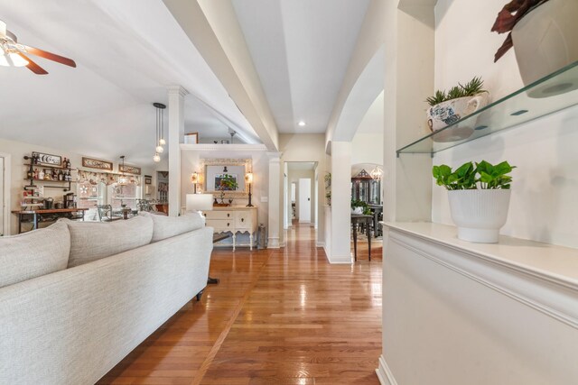 living room featuring decorative columns, wood finished floors, baseboards, recessed lighting, and a ceiling fan