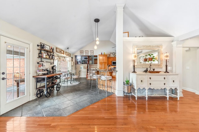 dining space with baseboards, wood finished floors, and lofted ceiling