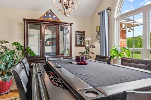 rec room featuring lofted ceiling and a chandelier