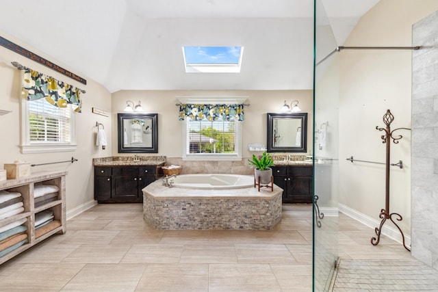 bathroom featuring a sink, lofted ceiling with skylight, a bath, and two vanities