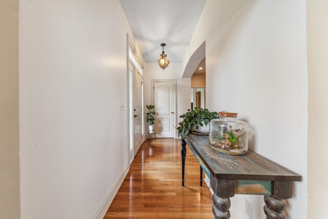 doorway with baseboards and wood finished floors