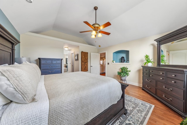 bedroom with lofted ceiling, baseboards, ceiling fan, light wood finished floors, and ensuite bath