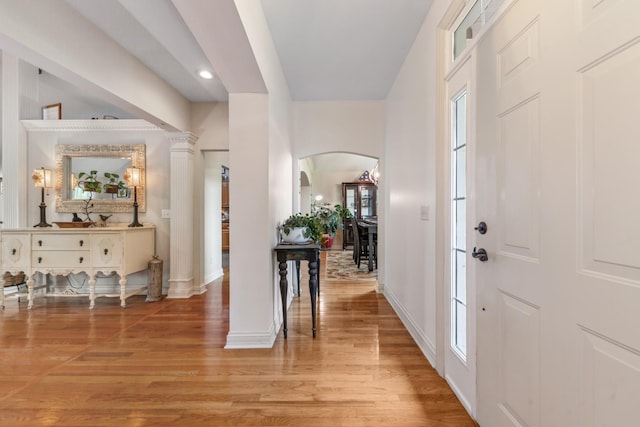 entrance foyer with light wood-style floors, arched walkways, baseboards, and recessed lighting