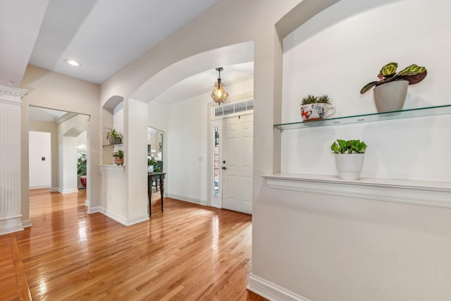 entryway featuring light wood-style floors, arched walkways, baseboards, and recessed lighting