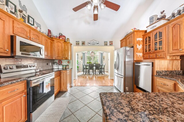 kitchen featuring a ceiling fan, appliances with stainless steel finishes, lofted ceiling, and light tile patterned floors