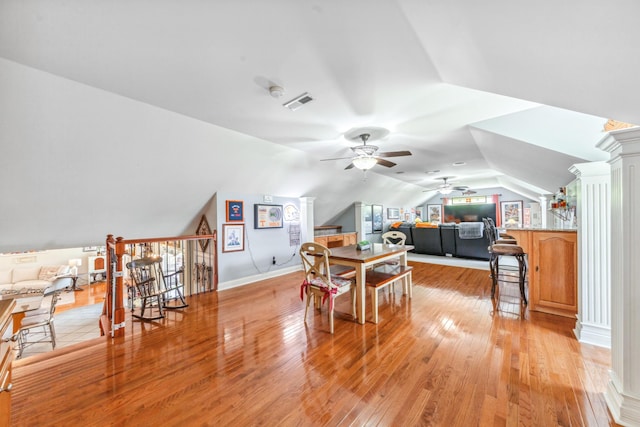 dining area with ceiling fan, visible vents, vaulted ceiling, baseboards, and light wood-style floors