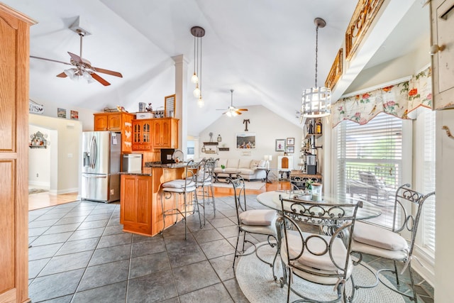 dining space featuring ceiling fan, high vaulted ceiling, and dark tile patterned flooring