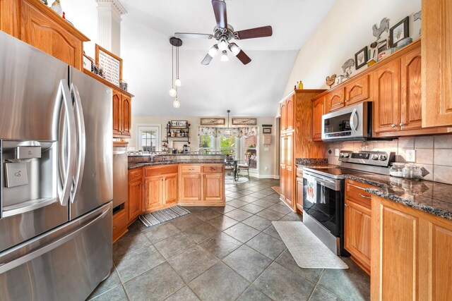 kitchen with ceiling fan, decorative light fixtures, appliances with stainless steel finishes, tasteful backsplash, and a peninsula