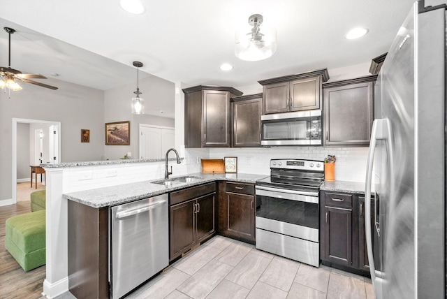 1804 Rains Rd, Clarksville, TN 37042 - kitchen featuring stainless steel appliances, dark brown cabinetry, a sink, and a peninsula