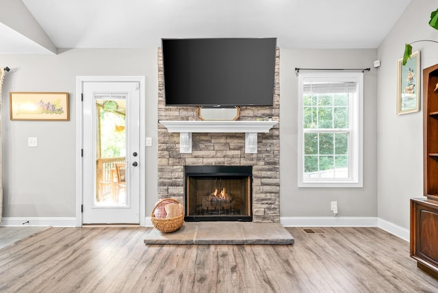 1804 Rains Rd, Clarksville, TN 37042 - unfurnished living room with baseboards, visible vents, a stone fireplace, and wood finished floors