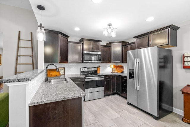1804 Rains Rd, Clarksville, TN 37042 - kitchen with dark brown cabinetry, light stone counters, a sink, appliances with stainless steel finishes, and backsplash
