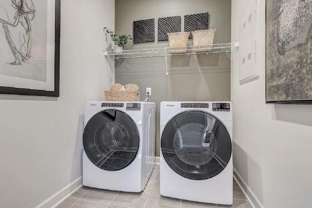 clothes washing area with baseboards, laundry area, washer and clothes dryer, and tile patterned floors