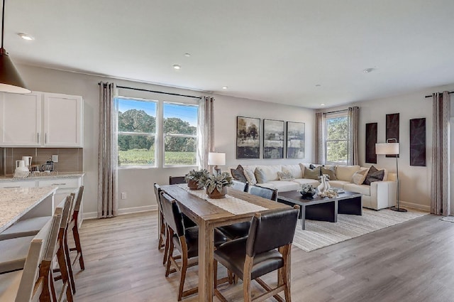 dining space with baseboards, recessed lighting, and light wood-style flooring