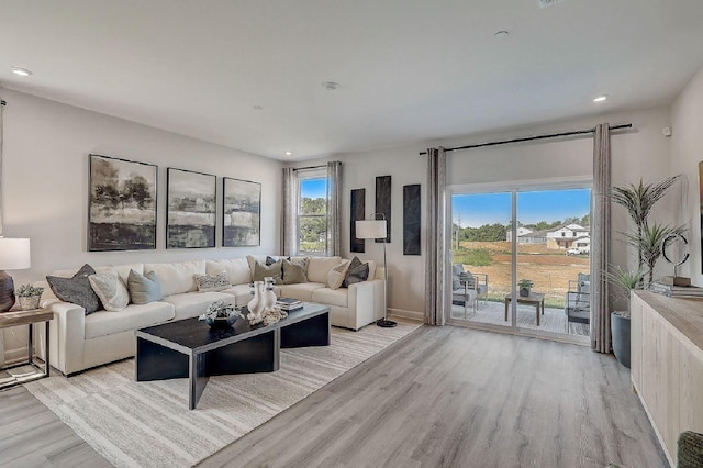 living area with light wood-type flooring, recessed lighting, and baseboards