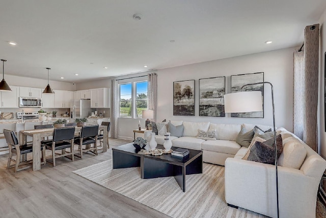 living area with recessed lighting and light wood-style flooring