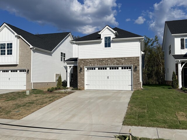 traditional-style house featuring concrete driveway, brick siding, a garage, and a front lawn